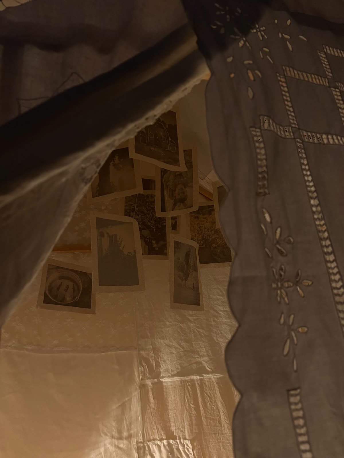 Photographs on linen beneath lace curtains