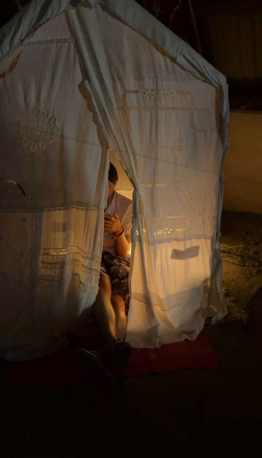 A visitor inside the lit textile house