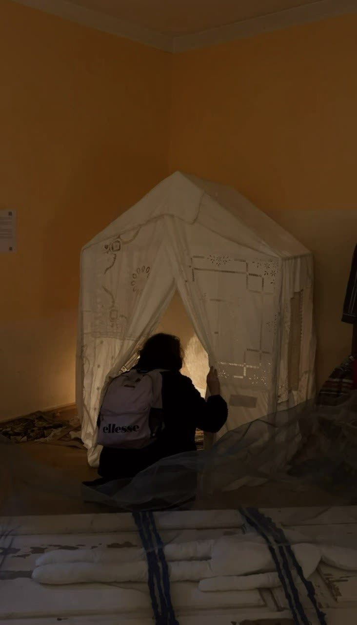 A visitor entering the textile house in an orange room