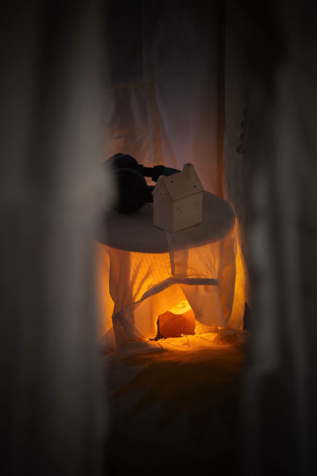 Headphones and a small ceramic house on a table inside